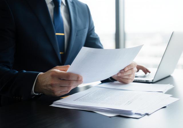 Legal professional reviewing complex commercial documents in a modern office